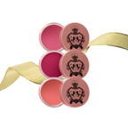 Set of four lip balm containers with a decorative ribbon by Luscious Cosmetics on a white background.