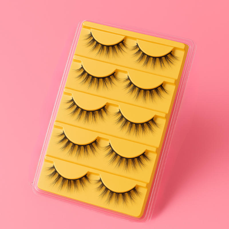 Luscious Cosmetics Bombshell 3D false eyelashes in a yellow case on a pink background.
