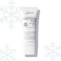 Luscious Cosmetics Ultra Protective Brightening Base SPF 45 tube displayed on a white background with snowflake decorations.