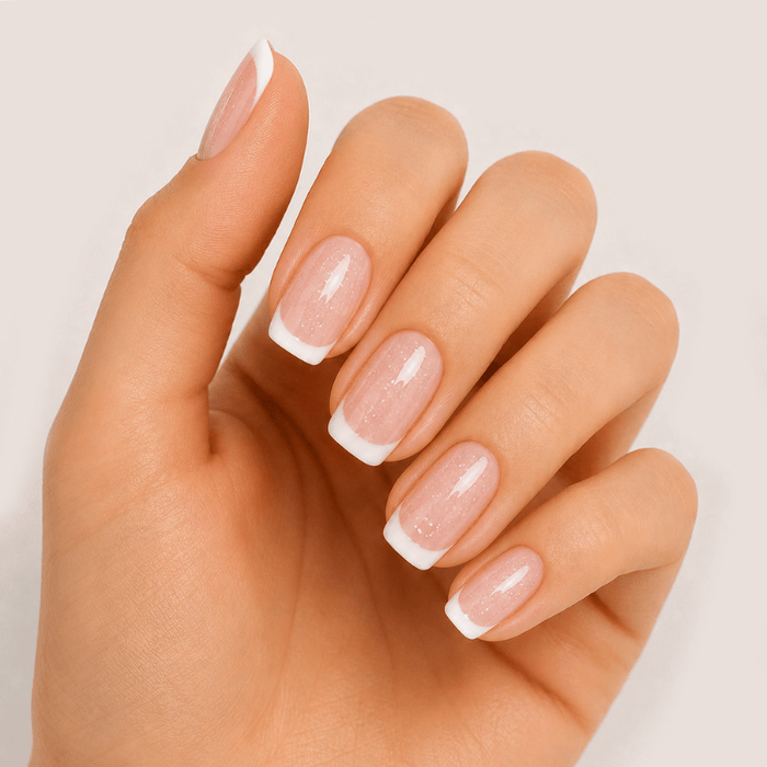 Hand wearing Luscious Cosmetics French Seashells short press-on nails with a glossy seashell-inspired design.