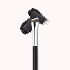 Luscious Cosmetics angled eyeliner brush with black bristles and handle shown beside black eyeliner powder.