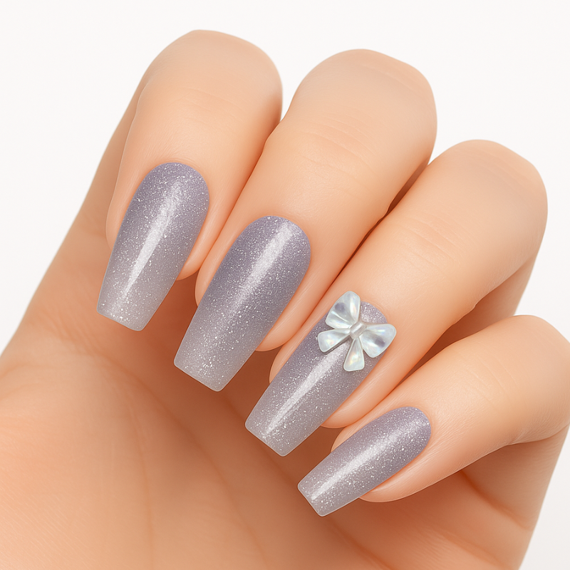 A hand wearing long, glossy lilac press-on nails by Luscious Cosmetics, featuring a floral design on the ring finger.