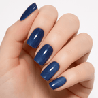 Close-up of a hand wearing Luscious Cosmetics press-on nails in a glossy blue finish.