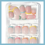 Clear plastic tray displaying Luscious Cosmetics press-on nails with pastel rainbow-colored tips.