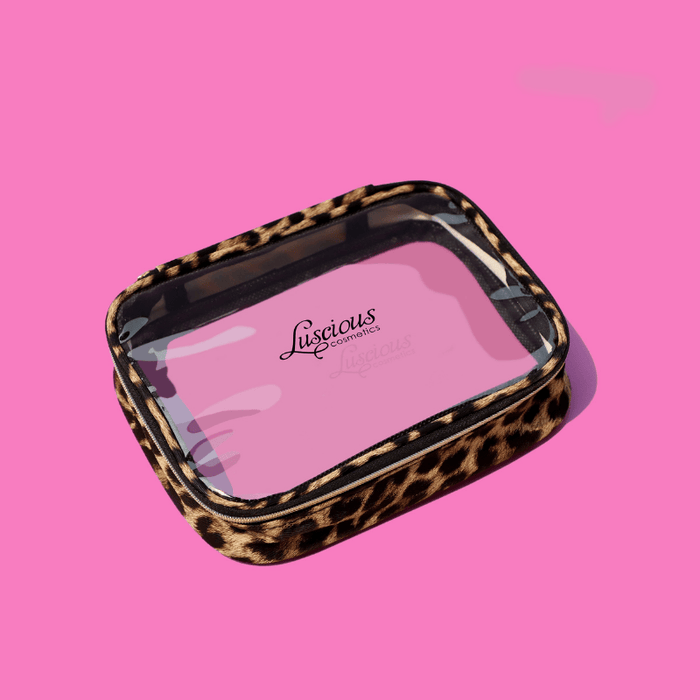 Luscious Cosmetics Cheetah Chic makeup bag with leopard print trim on a pink background.